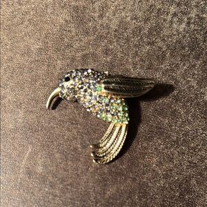 Monet classic gold tone pin with purple and green rhinestones.